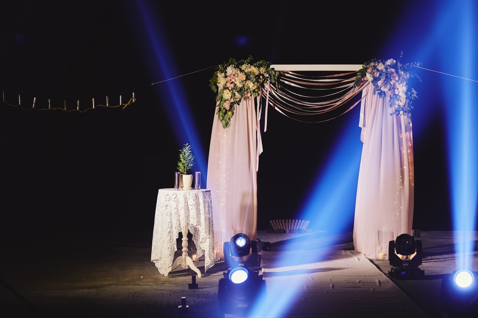 Night ceremony with light and fire show. The wedding arch is decorated with flowers at night ceremon